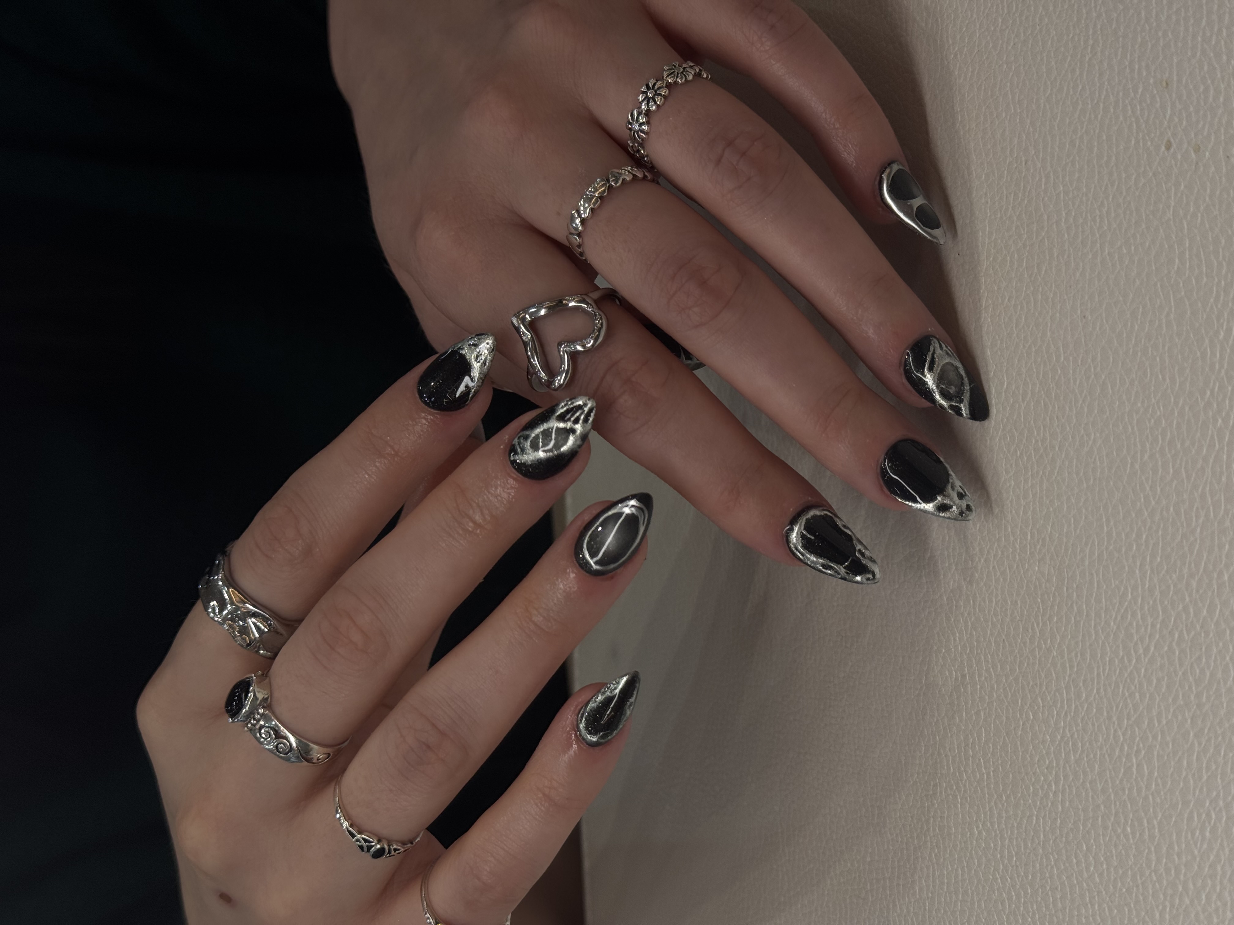 Almond nails with black bases and molten silver 3D detail