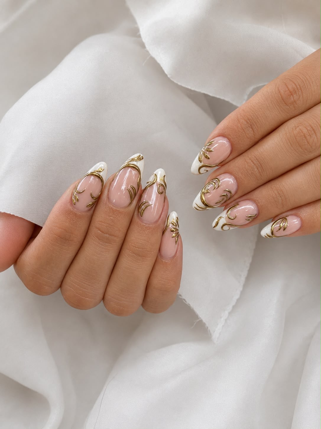 Almond nails with white French tips and raised gold filigree detail