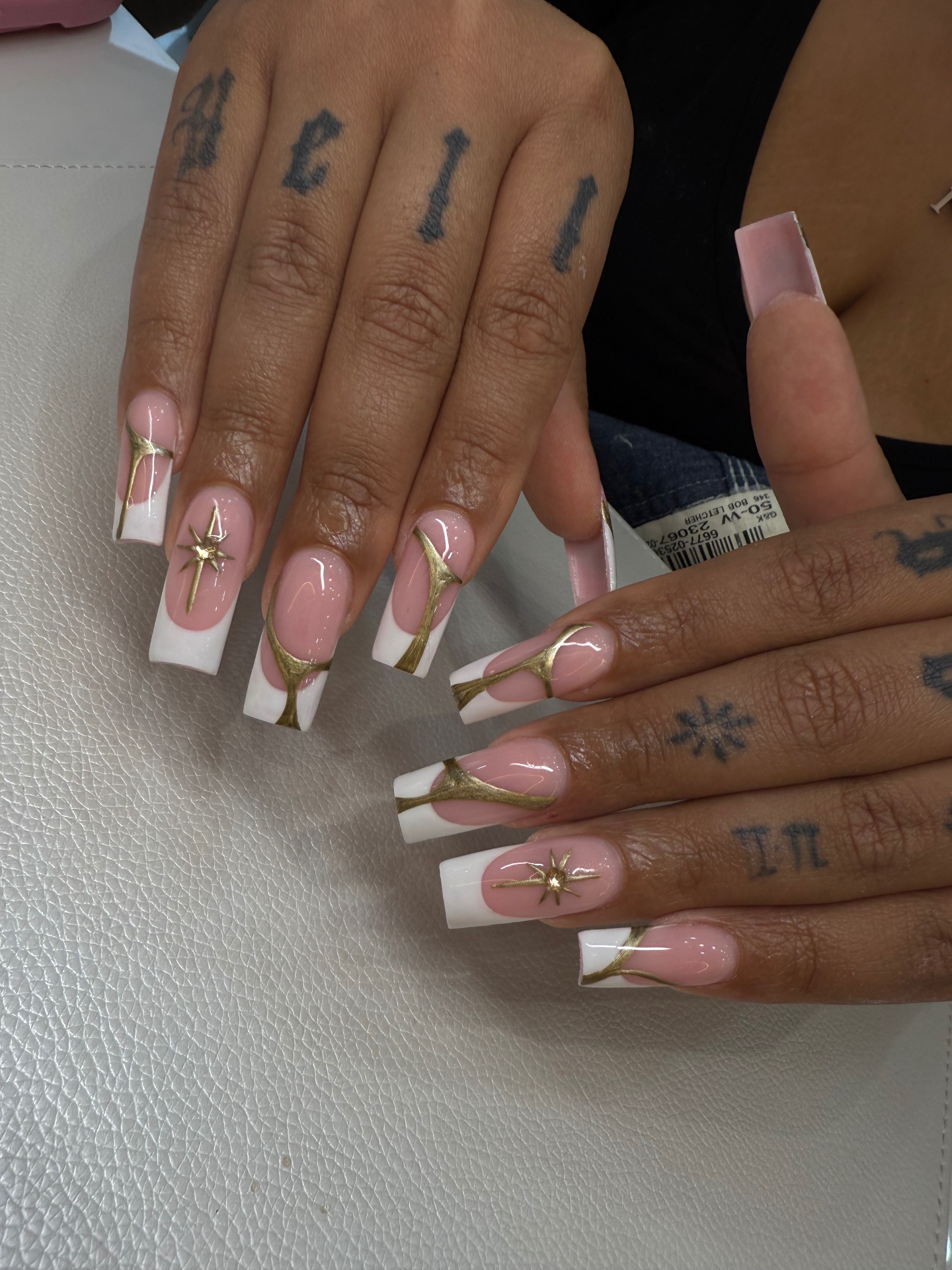 White French tips with hand-painted gold detail and star accents