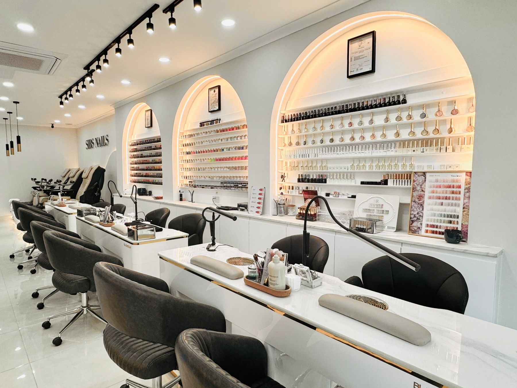 Manicure stations beneath arched polish displays